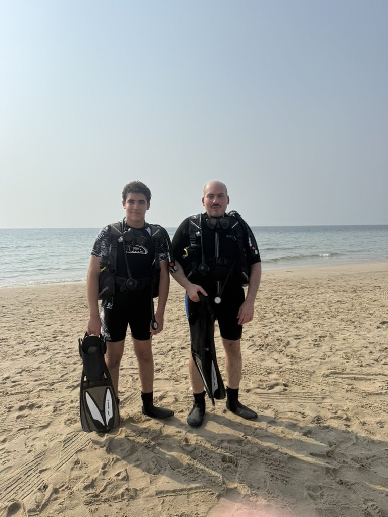 Zyad and his dad in scuba gear on the beach